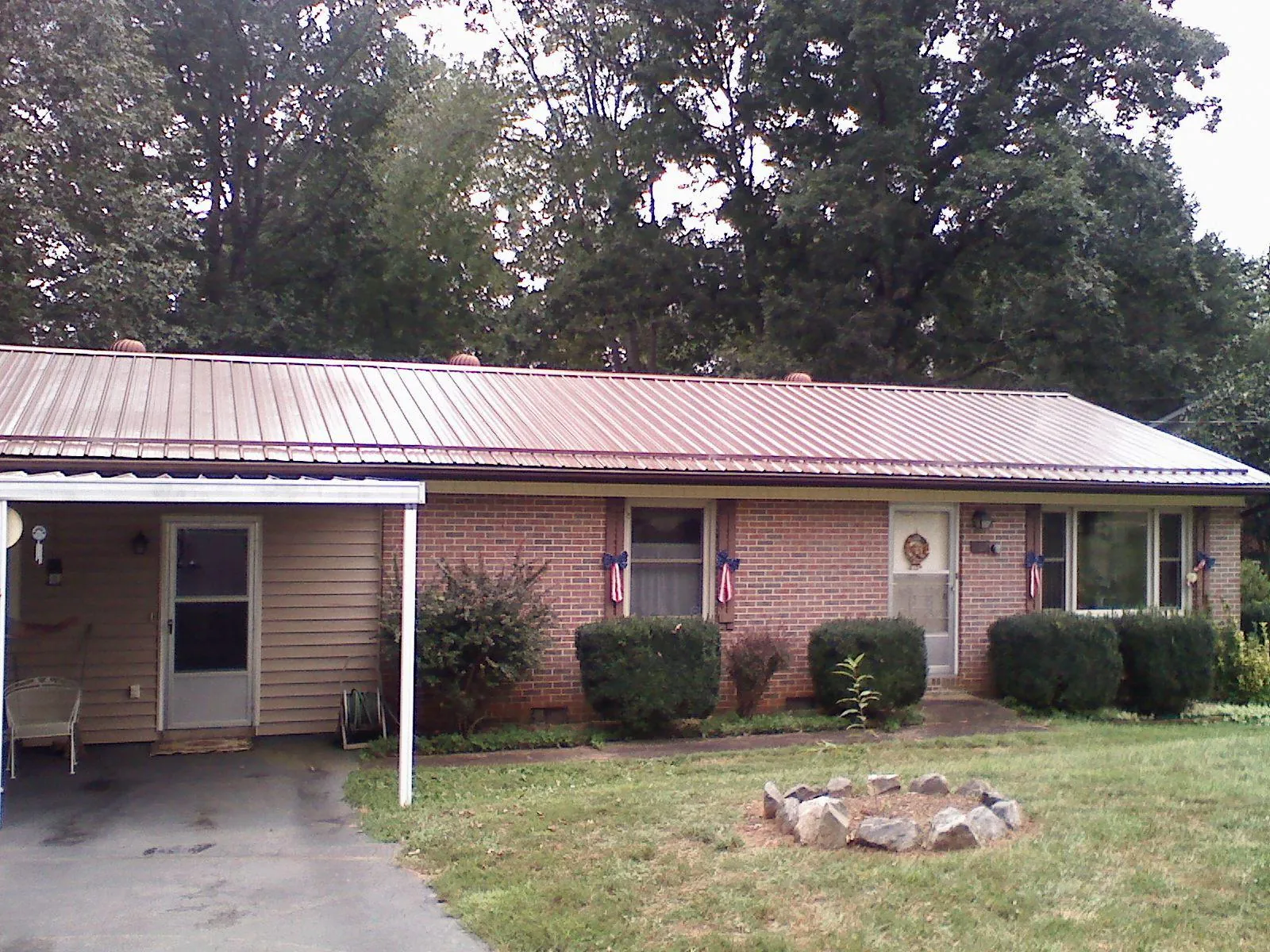 Bronze metal roof and carport on a brick ranch home — Roof Repair work by our crew in Oslo